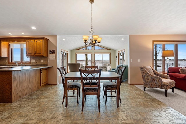 dining space with light colored carpet, vaulted ceiling, sink, and an inviting chandelier