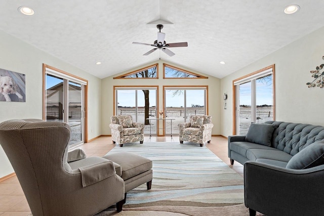 living room with ceiling fan, light tile patterned floors, vaulted ceiling, and a textured ceiling