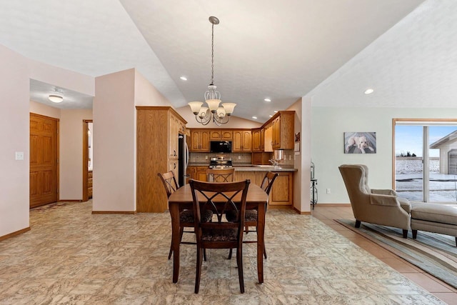 dining room with sink, lofted ceiling, and an inviting chandelier