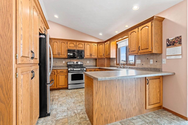 kitchen featuring backsplash, appliances with stainless steel finishes, kitchen peninsula, and lofted ceiling