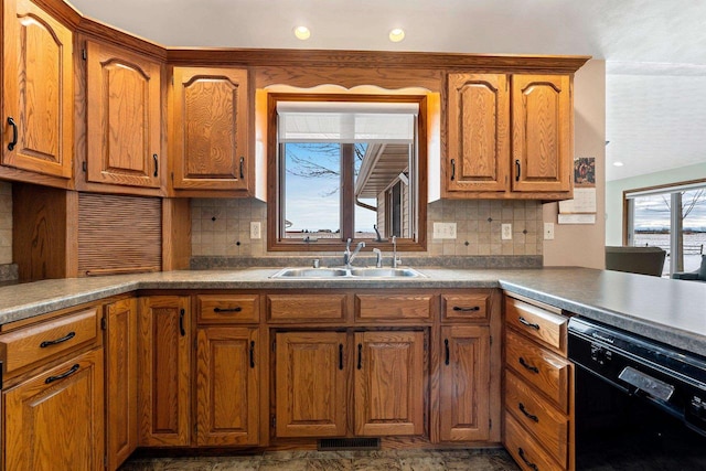 kitchen featuring sink, dishwasher, tasteful backsplash, and a healthy amount of sunlight