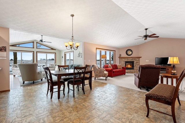 dining area featuring vaulted ceiling and ceiling fan with notable chandelier