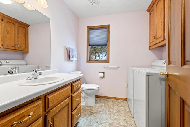 bathroom with toilet, vanity, and independent washer and dryer