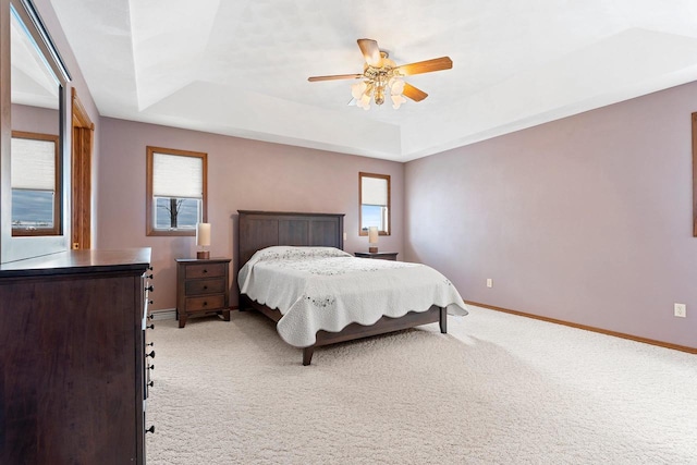 bedroom with ceiling fan, carpet, and a raised ceiling