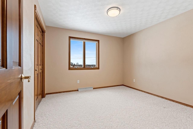 unfurnished bedroom featuring light colored carpet, a closet, and a textured ceiling