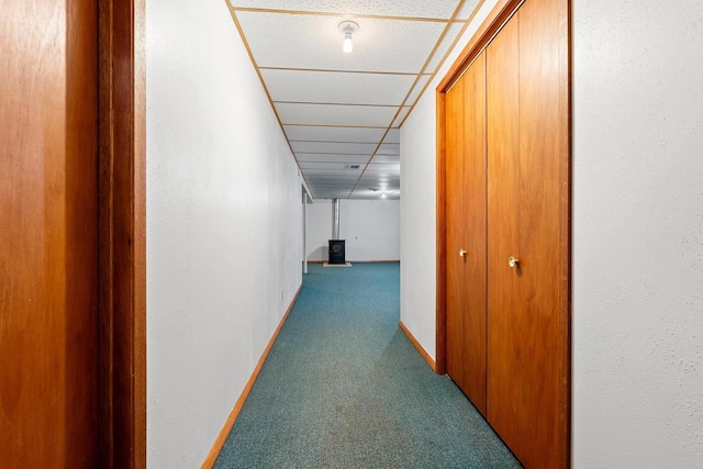 corridor featuring a drop ceiling and carpet floors