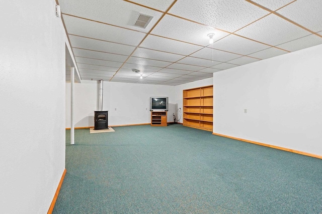 basement featuring built in shelves, a paneled ceiling, and carpet flooring