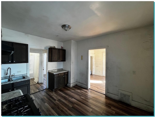 kitchen featuring exhaust hood, dark hardwood / wood-style flooring, sink, and dark brown cabinets