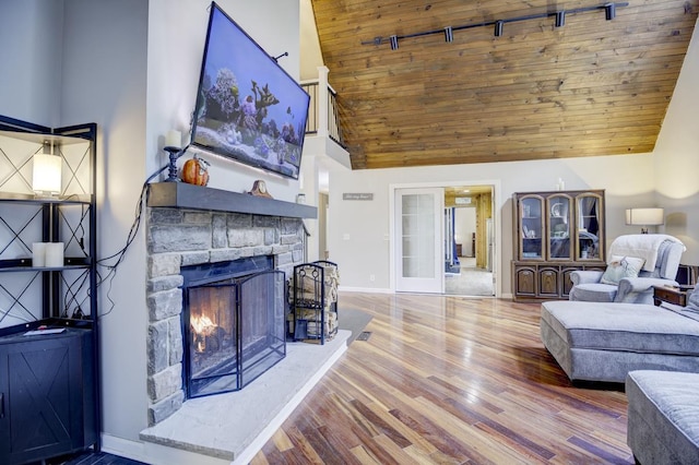 living room featuring high vaulted ceiling, wood-type flooring, wood ceiling, and a fireplace