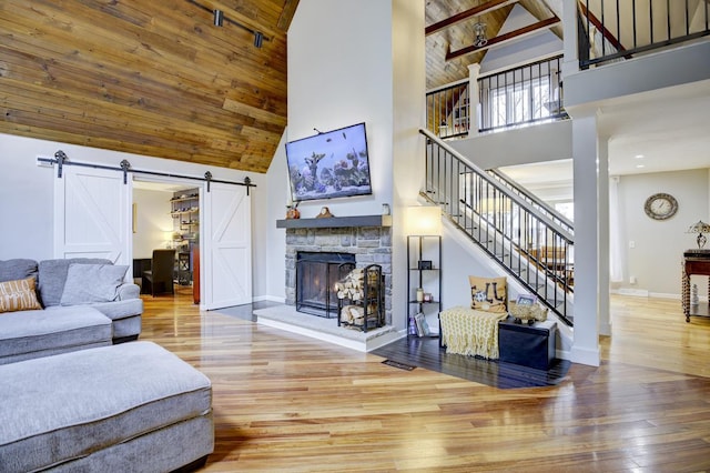 living room with a barn door, hardwood / wood-style floors, beamed ceiling, wood ceiling, and high vaulted ceiling