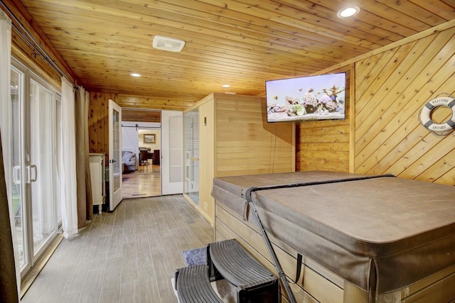 rec room featuring french doors, wood ceiling, wooden walls, and light hardwood / wood-style floors