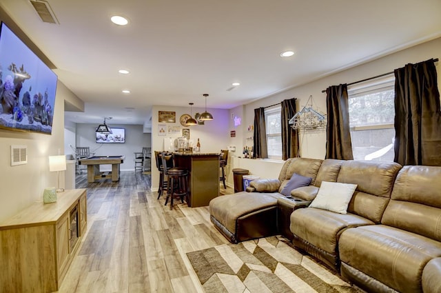 living room with light hardwood / wood-style flooring and bar area