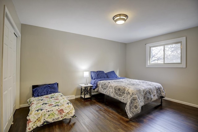 bedroom with dark hardwood / wood-style floors and a closet