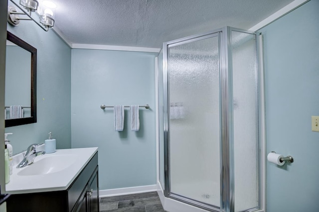 bathroom with vanity, a textured ceiling, wood-type flooring, and walk in shower