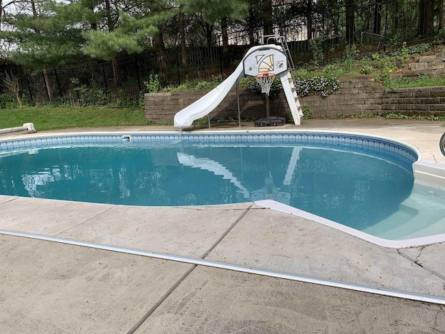 view of swimming pool with a water slide