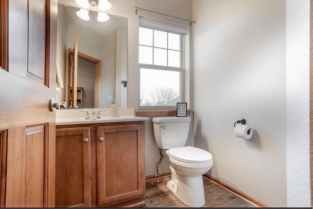 bathroom with toilet, wood-type flooring, and vanity