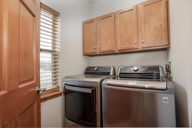 laundry room featuring independent washer and dryer and cabinets