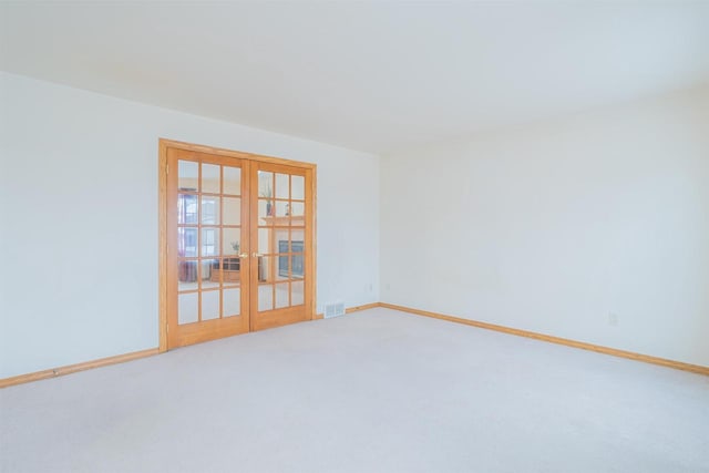 spare room featuring carpet flooring and french doors