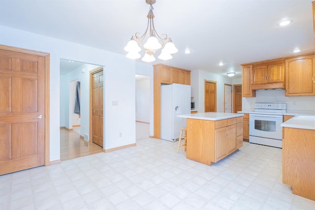 kitchen featuring white appliances, a kitchen island, a kitchen bar, hanging light fixtures, and a chandelier