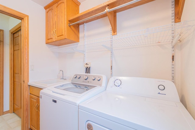 washroom with washing machine and dryer, sink, and cabinets