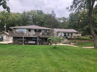 back of house featuring a deck and a yard