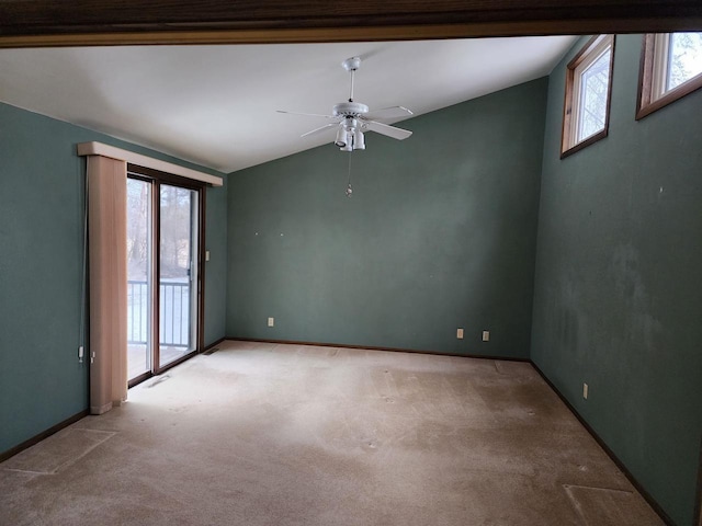 spare room with vaulted ceiling, ceiling fan, a wealth of natural light, and light carpet