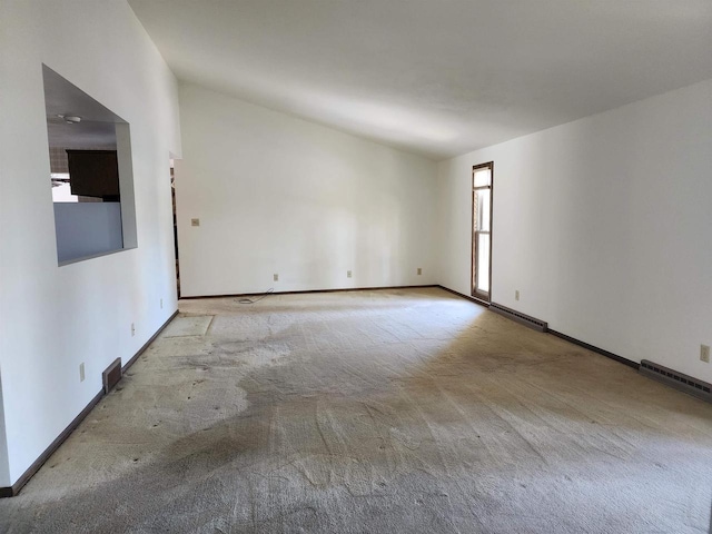 carpeted spare room with lofted ceiling