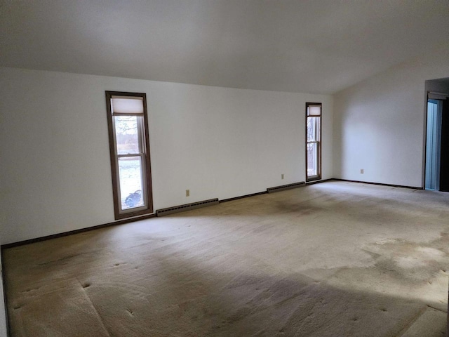 carpeted empty room featuring lofted ceiling and a baseboard radiator