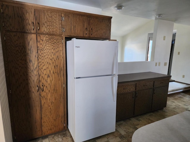 kitchen with lofted ceiling and white fridge