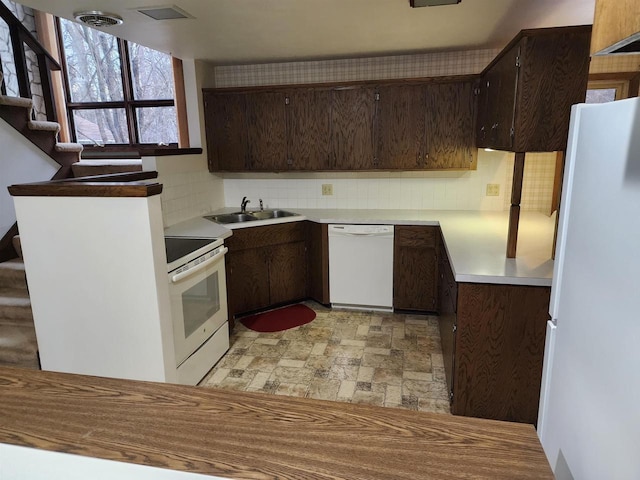 kitchen with sink, white appliances, backsplash, and dark brown cabinetry