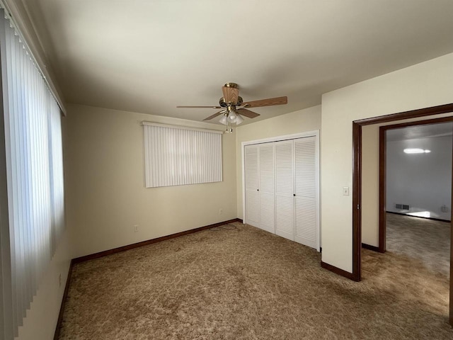 unfurnished bedroom with ceiling fan, a closet, and carpet floors