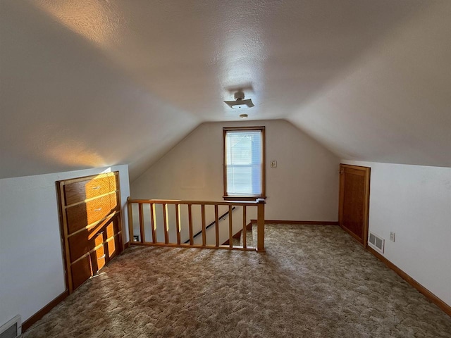 bonus room featuring a textured ceiling, lofted ceiling, and carpet flooring