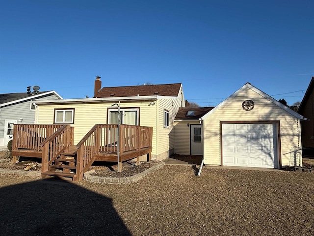 rear view of house featuring a deck, an outdoor structure, and a garage