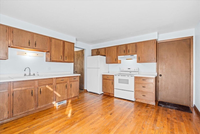 kitchen featuring sink, light hardwood / wood-style flooring, and white appliances