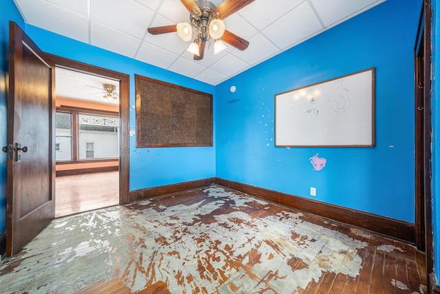 spare room with ceiling fan, a paneled ceiling, and hardwood / wood-style flooring