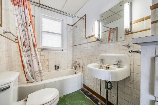 bathroom featuring toilet, tile walls, and shower / bath combination with curtain