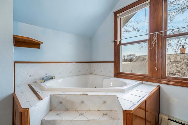 bathroom with lofted ceiling, tiled tub, and a baseboard radiator