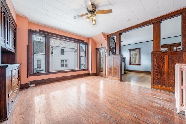 unfurnished living room with radiator, ceiling fan, and light hardwood / wood-style flooring