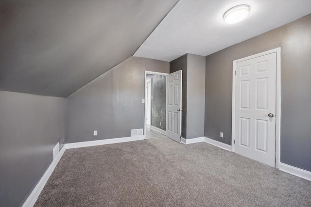 bonus room with lofted ceiling and light colored carpet