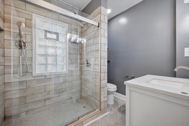 bathroom with toilet, walk in shower, plenty of natural light, and vanity