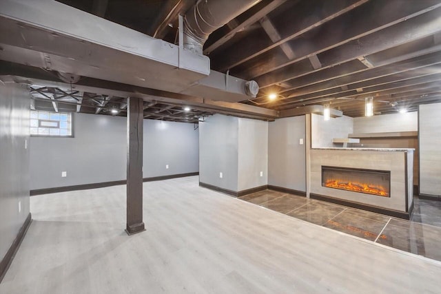 basement with a tiled fireplace and hardwood / wood-style floors