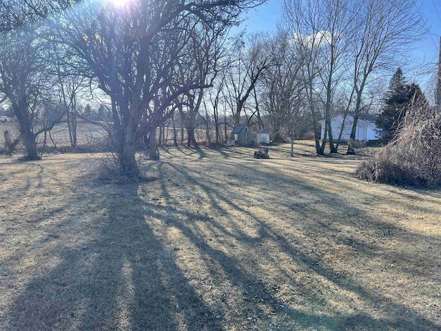 view of yard with a storage shed and a rural view
