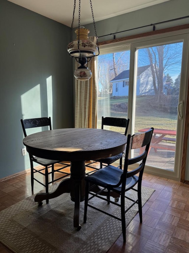 dining space with parquet flooring