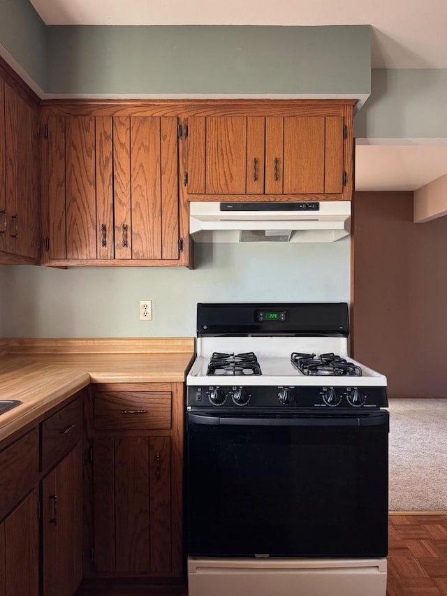 kitchen with exhaust hood, dark parquet flooring, and black range with gas cooktop