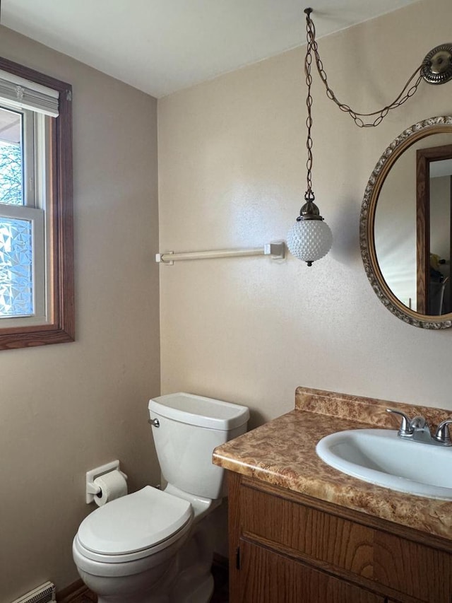 bathroom featuring a baseboard heating unit, toilet, and vanity