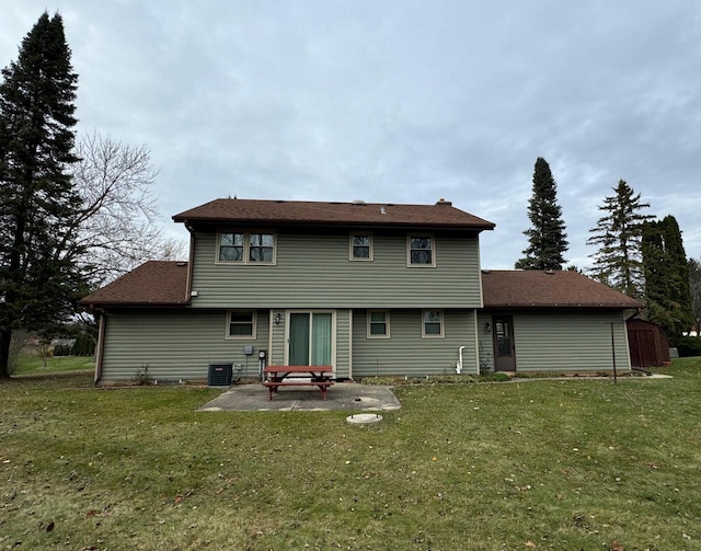 rear view of house featuring central AC, a yard, and a patio