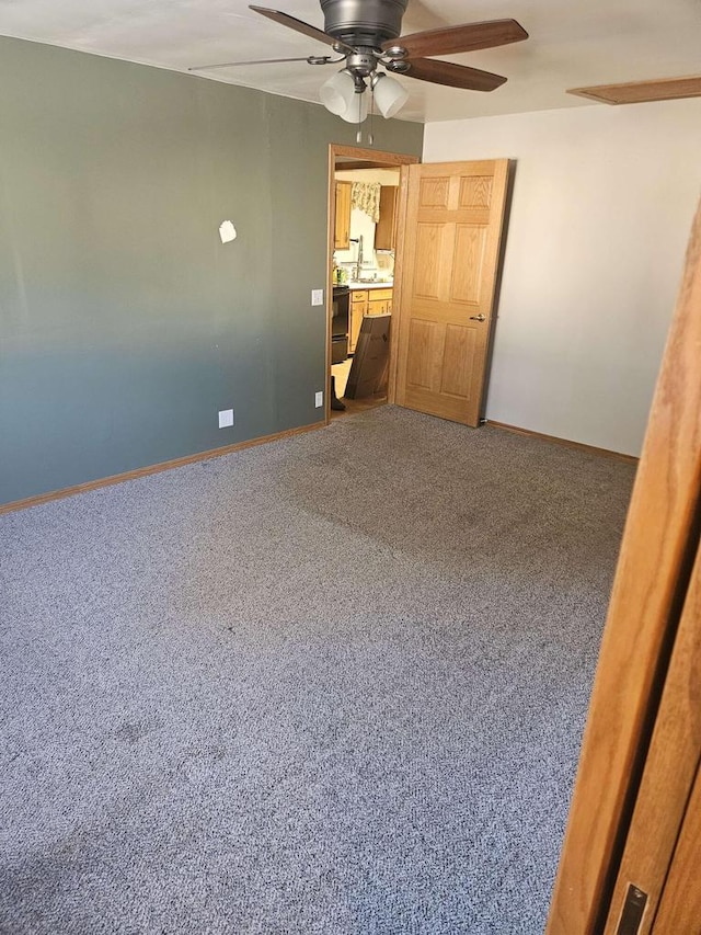 carpeted empty room with ceiling fan and sink