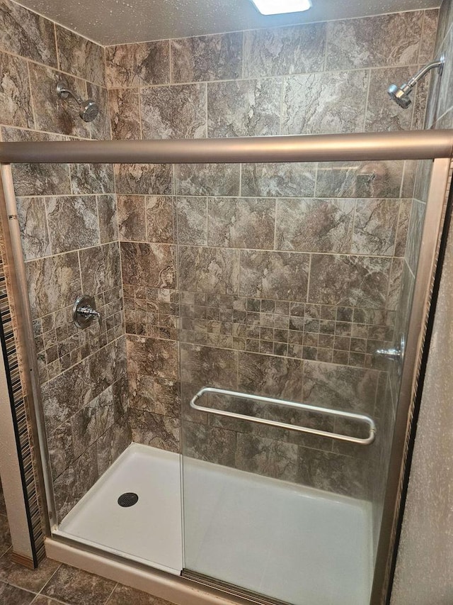 bathroom with tile patterned flooring and a shower with door