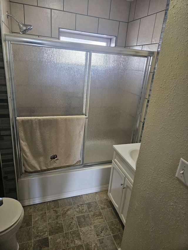 full bathroom featuring toilet, enclosed tub / shower combo, and vanity