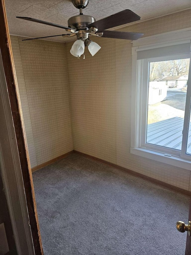 carpeted spare room featuring ceiling fan